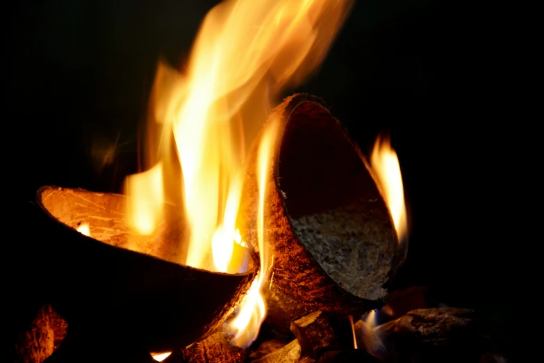 a pile of logs with lots of yellow and red fire in it