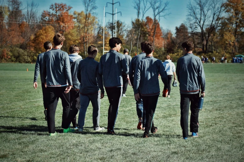 the soccer team huddle together in an open field