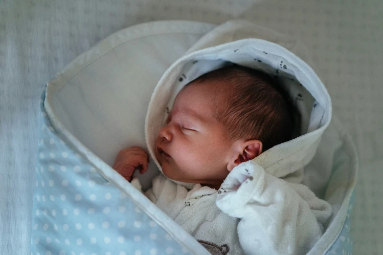 a baby is curled up in the crib with its eyes closed