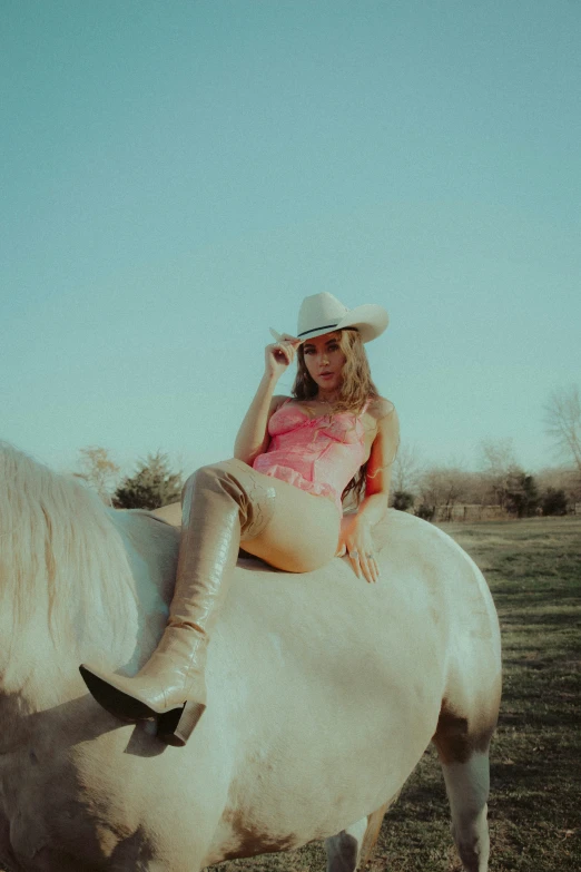 a woman in pink is sitting on top of a white horse