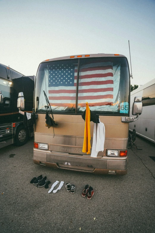 a bus has a flag and several shoes in front of it