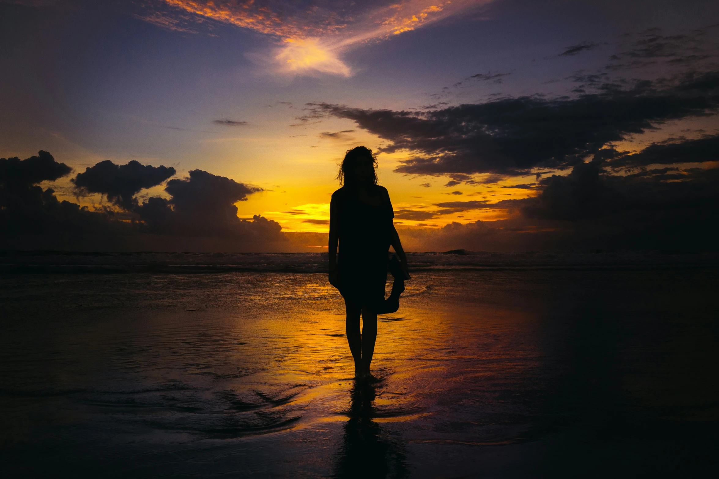 a person walks across the water during a sunset