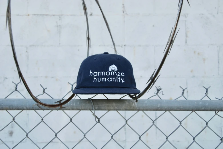 a hat with a blue band is on top of a fence