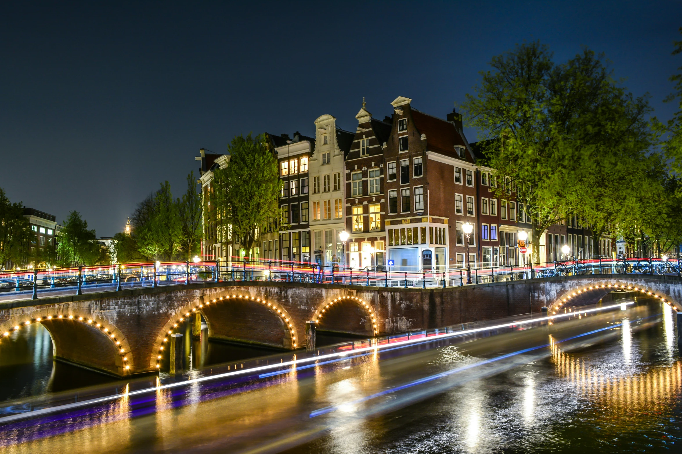 a bridge and buildings on a river at night