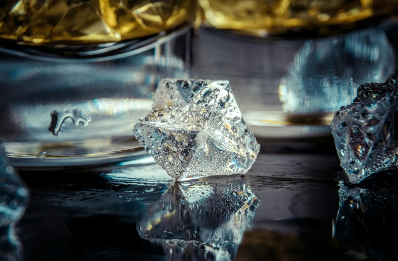 several pieces of ice sit on a reflective surface