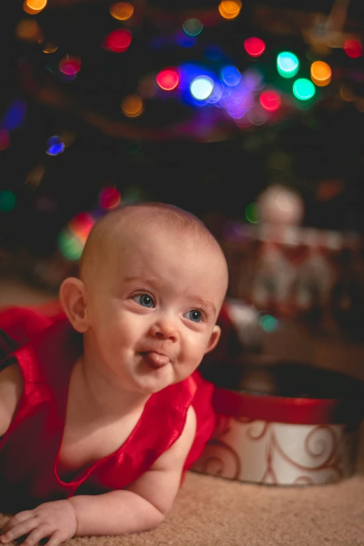 there is a baby smiling and laying on the ground