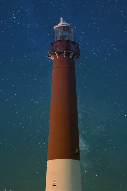 a big light house sitting next to some water