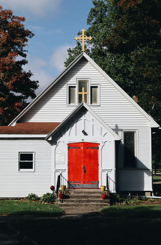 the small white church is decorated with bright red doors