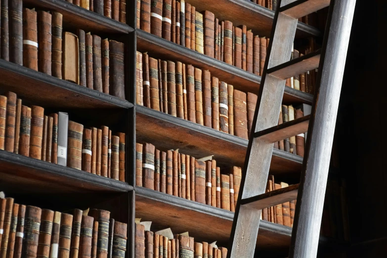the wall is full of many books that are hanging from the ceiling
