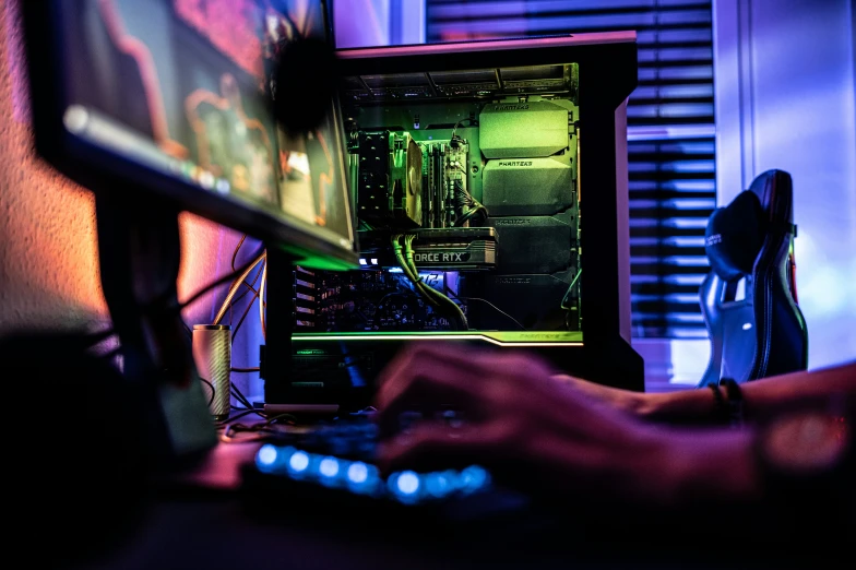 a man with his hand on a keyboard next to a monitor