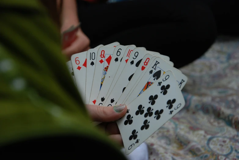 a person holding four playing cards in their hands