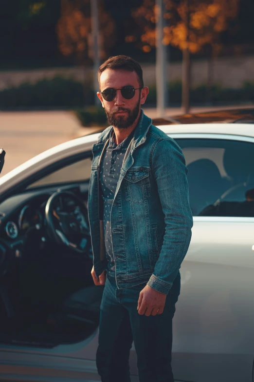 a man standing next to a silver car