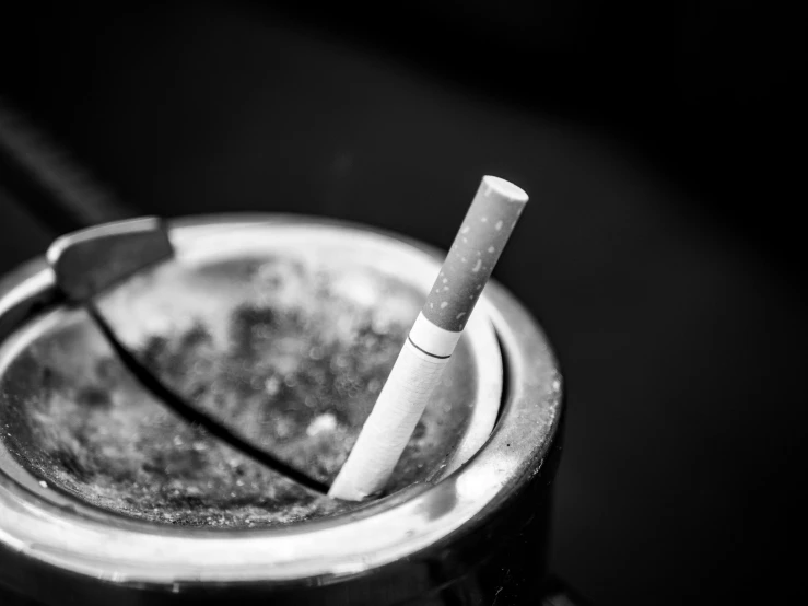 two cigarettes are sitting inside of a metallic cup