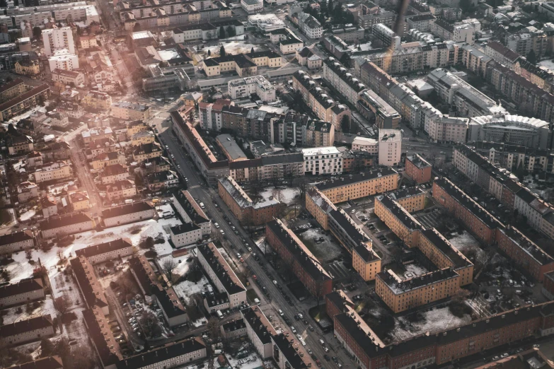 the aerial view of city buildings with the roofs partially covered by snow