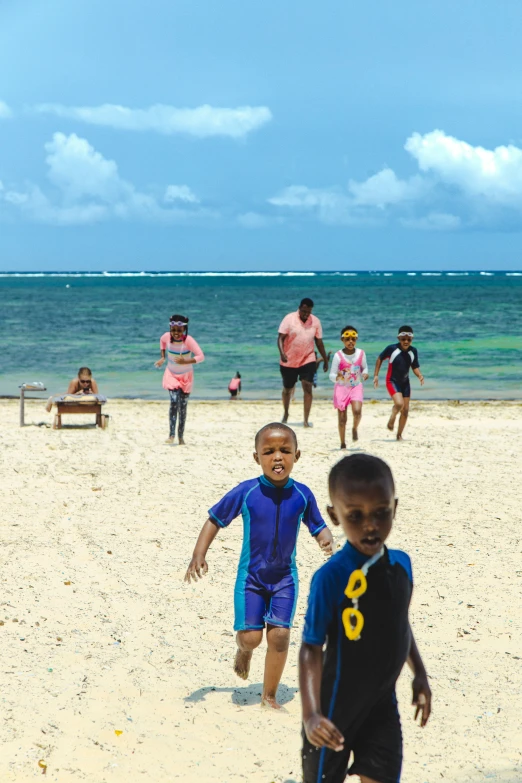 a group of s playing soccer on the beach