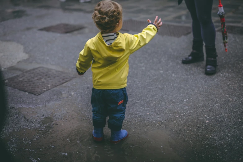 a toddler wearing a yellow shirt playing outside