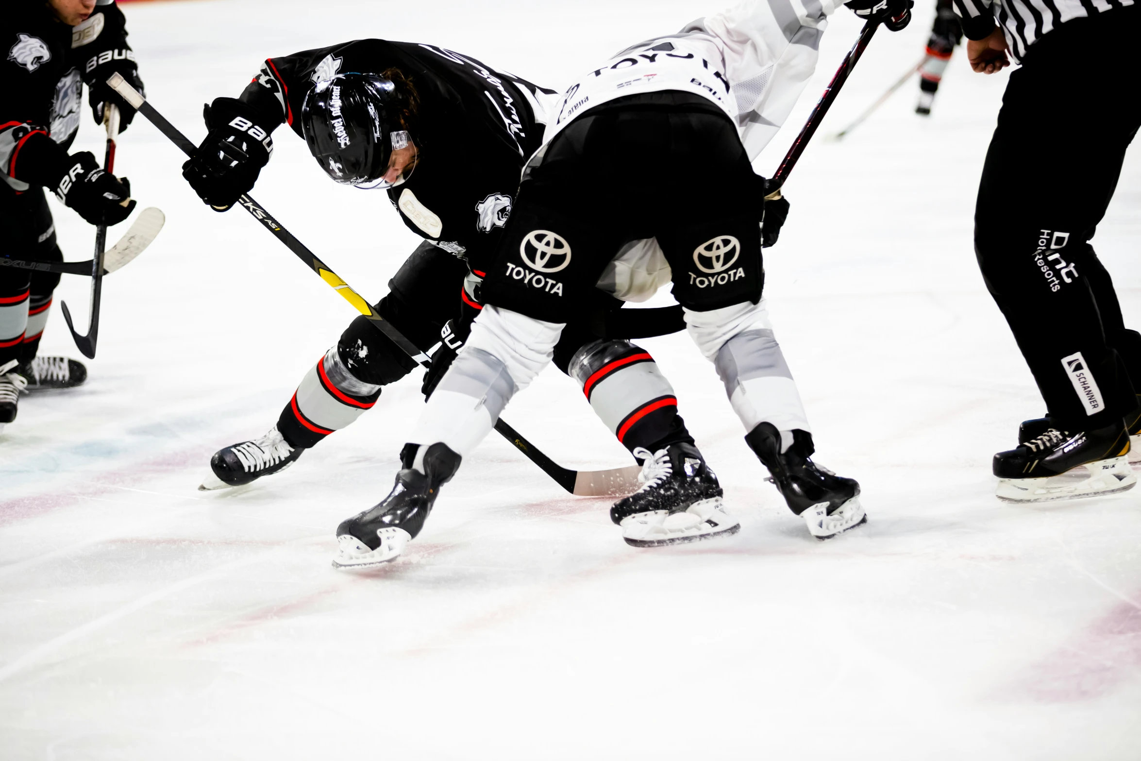 several people in uniform playing hockey together on an ice rink