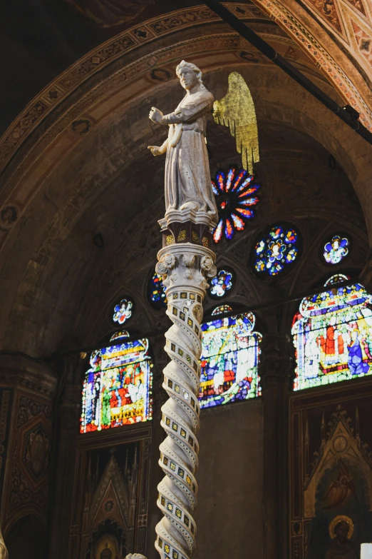 an intricate sculpture is placed on top of a pole in the cathedral