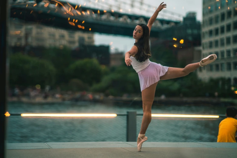 a ballerina performing on a rooftop by the water