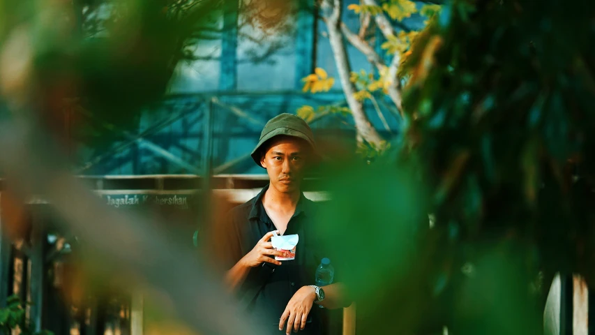 a woman in black shirt sitting on bench drinking from a cup