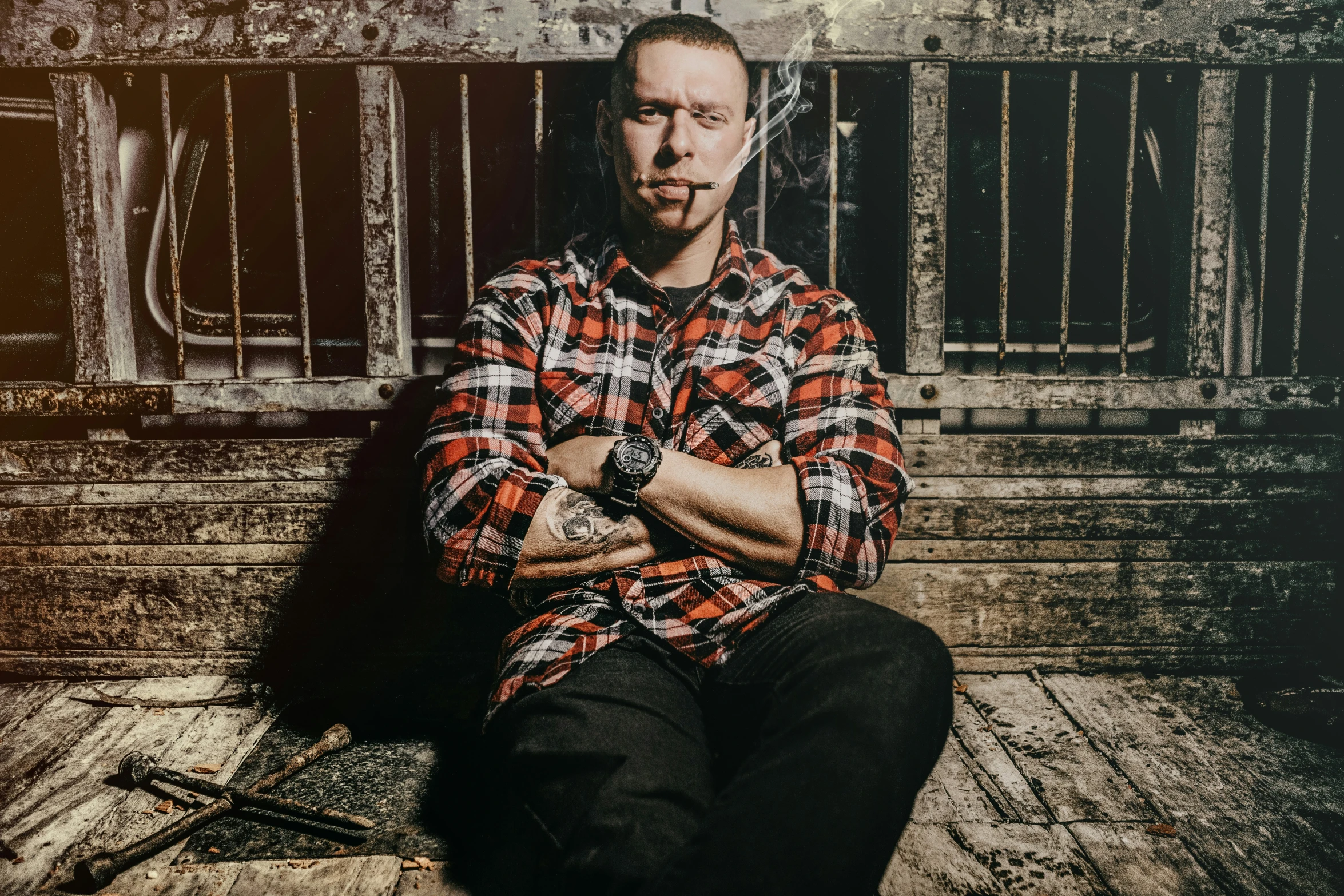 a man sits on steps in front of a gate and sticks his tongue into his mouth