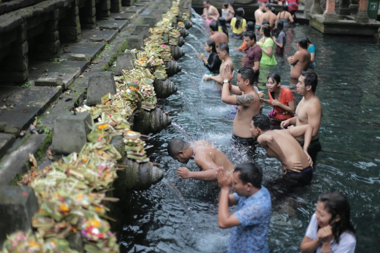 a group of people in water swimming in a small pond