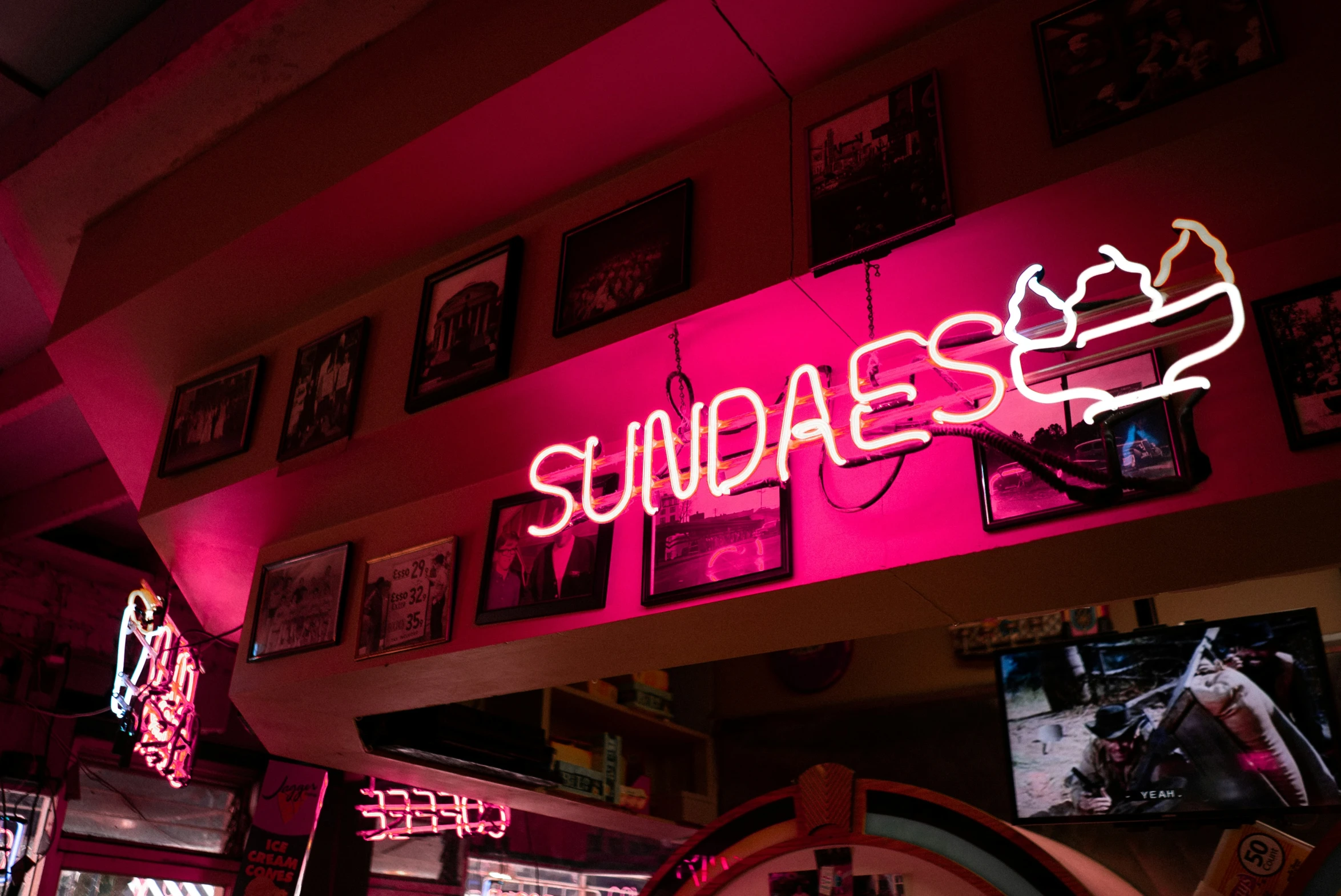 a neon sign is mounted on the wall over a tv