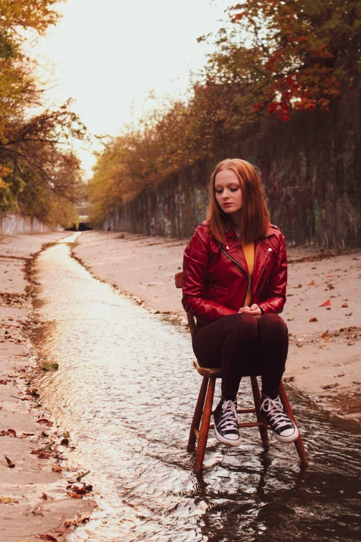 a woman sitting on a chair in a flooded street