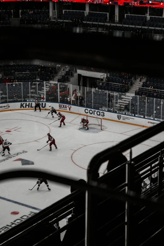 hockey players playing on a hockey rink in an empty stadium