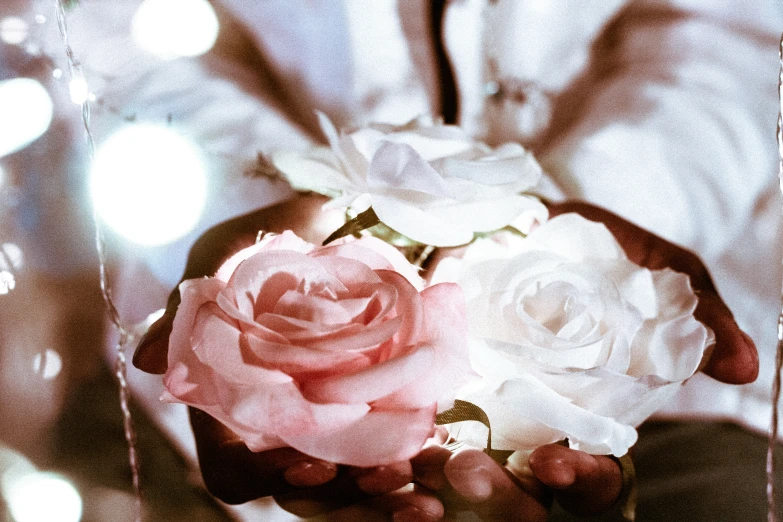 flowers in someone's hand near a mirror