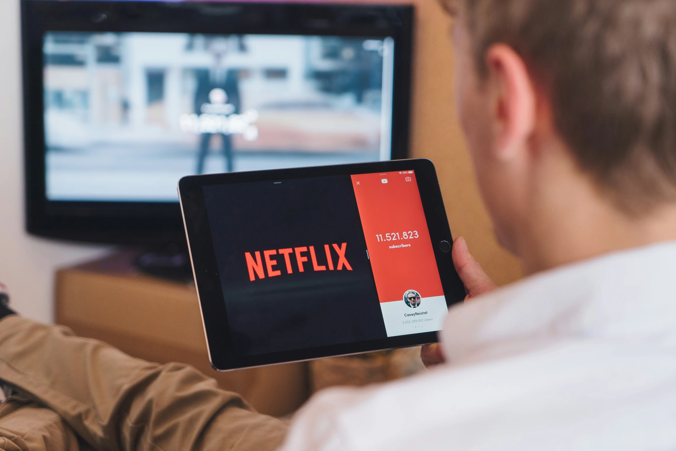 a man with a tablet holding up a tv on the screen