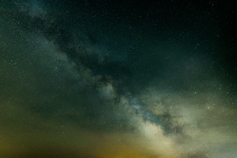 a dark colored sky with a bright yellow spot in the center