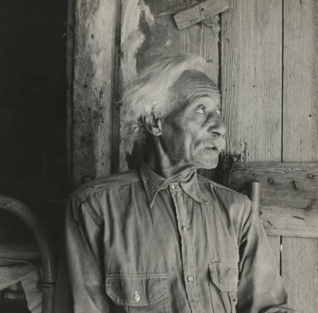 black and white image of a man wearing a hat