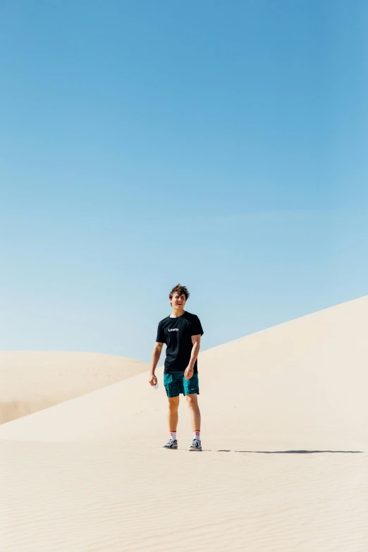 a man walks through the sand dunes