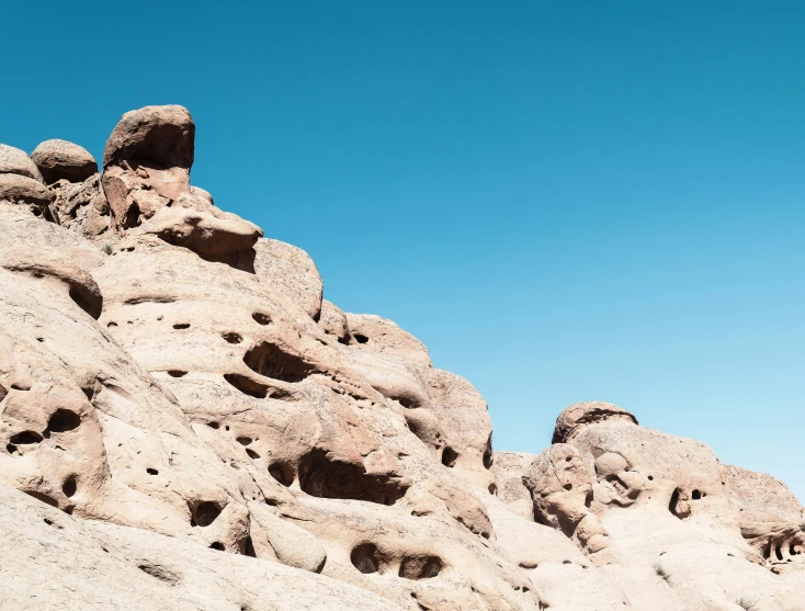 a large rock face in the middle of a desert