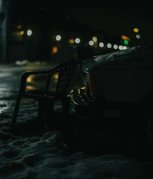 a parked car next to a park bench and some street lights