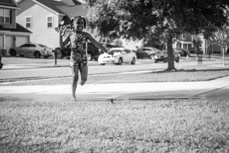 a person is in the air in a yard near cars