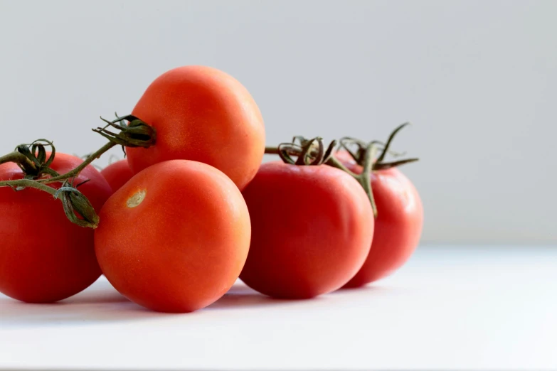 five red tomatoes sitting on top of each other