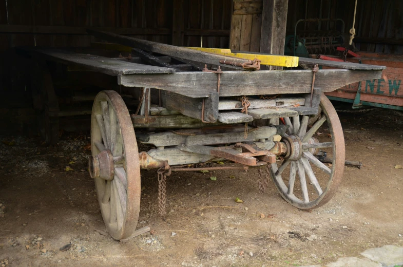 a wagon that is sitting outside of a barn