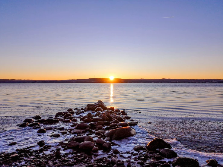 some rocks water and a sunset