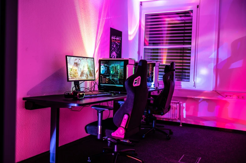 a black gaming desk with a purple light behind it