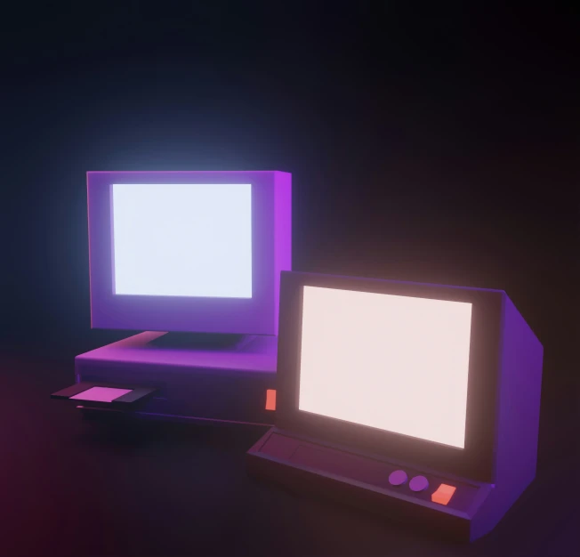 two computers on a table in a darkened room