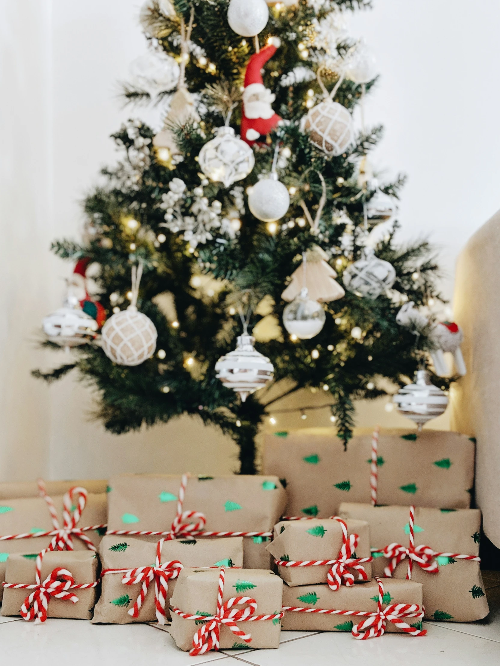 many gifts stacked next to a christmas tree