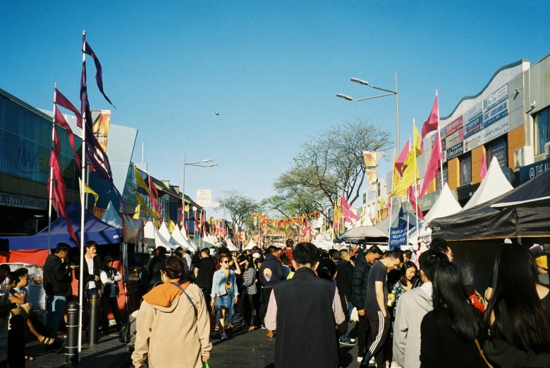 many people are walking in a crowded outdoor marketplace