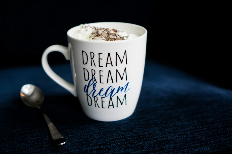 a spoon and cup sitting on top of a blue table