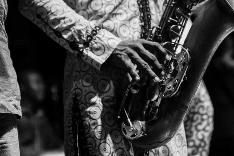 a black and white pograph of a man holding a saxophone