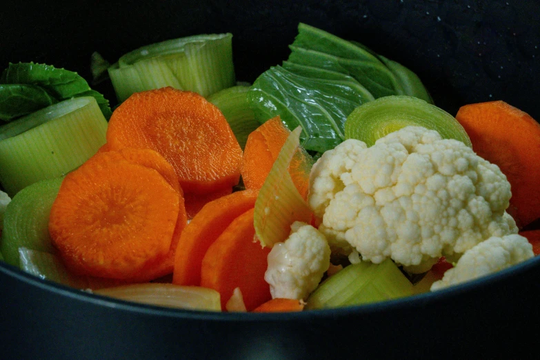 assorted diced vegetables are in a black bowl