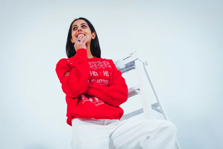 a person with a red sweater on sitting down in a chair