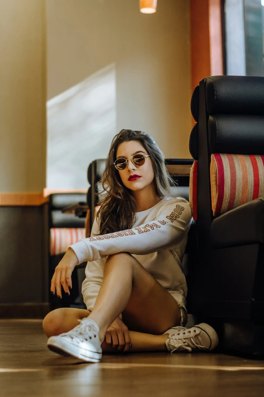 a woman wearing sunglasses is sitting on the floor