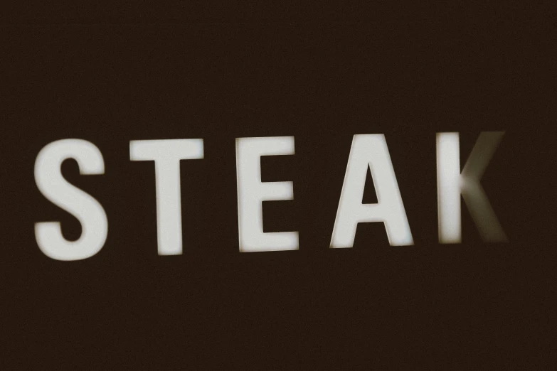 a dark picture of the words steak are lit up